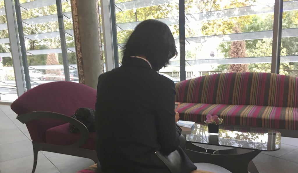 In this October 7 file picture, Grace Meng, the wife of detained Interpol President Meng Hongwei, consults her mobile phone in the lobby of a hotel in Lyon, central France, where the police agency is based. Photo: AP In this October 7 file picture, Grace Meng, the wife of detained Interpol President Meng Hongwei, consults her mobile phone in the lobby of a hotel in Lyon, central France, where the police agency is based. Photo: AP