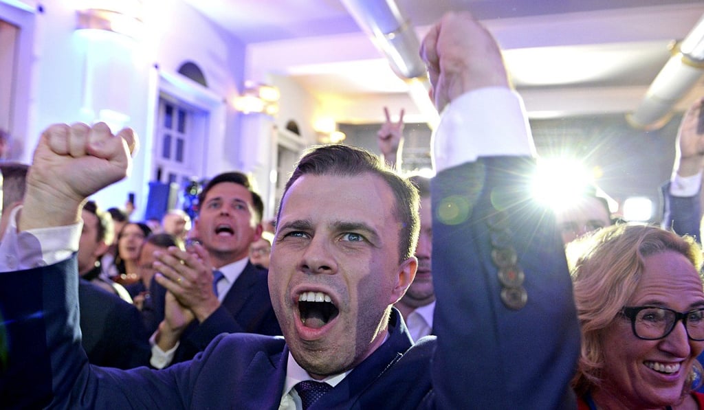 Opposition supporters react as first exit polls are announced in Warsaw. Photo: AP Photo
