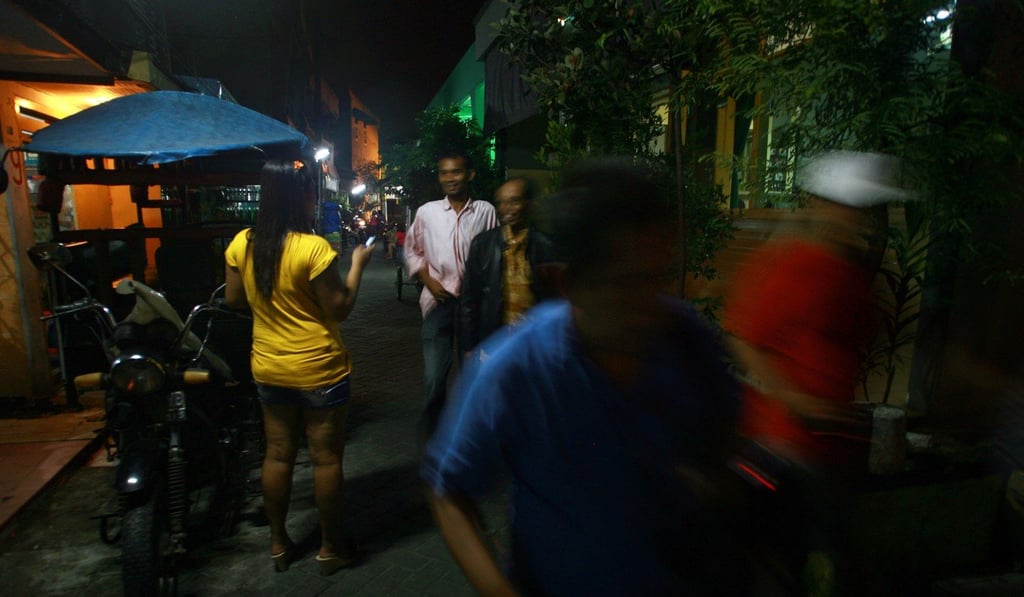 A sex worker standing outside a brothel in a popular red-light district in the Indonesian city of Surabaya. Photo: AFP A sex worker standing outside a brothel in a popular red-light district in the Indonesian city of Surabaya. Photo: AFP