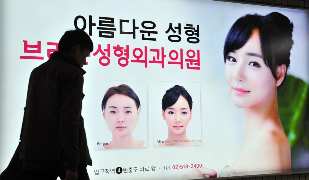 A pedestrian walks past an advertisement for a plastic surgery clinic at a subway station in Seoul, South Korea. Photo: AFP A pedestrian walks past an advertisement for a plastic surgery clinic at a subway station in Seoul, South Korea. Photo: AFP