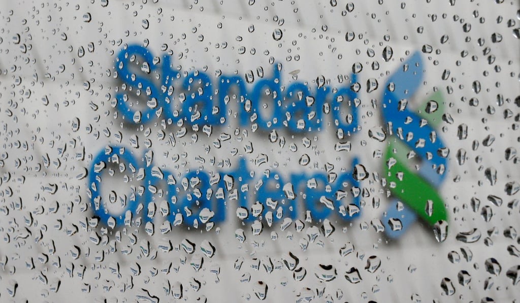 A Standard Chartered logo at its headquarters is seen through a window in Hong Kong. Standard Chartered is among a group of global banks that have told staff to postpone or reconsider travel in China. Photo: Reuters