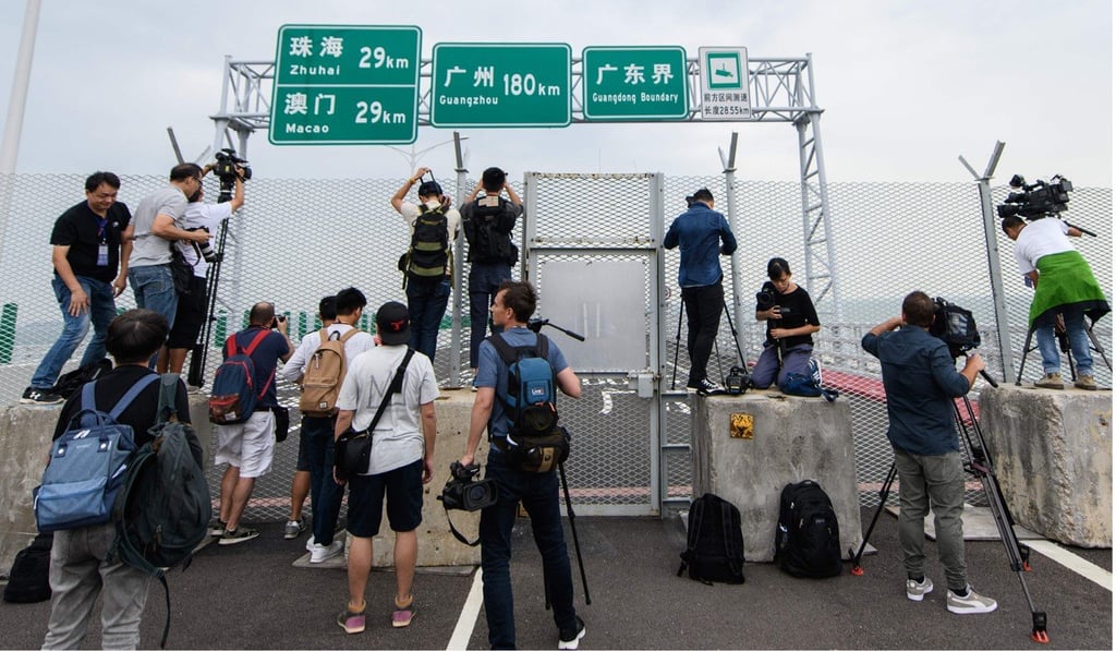 Media gather at a barrier placed in front of the boundary crossing at the Hong Kong side of the Hong Kong-Zhuhai-Macau Bridge on Friday. Photo: AFP