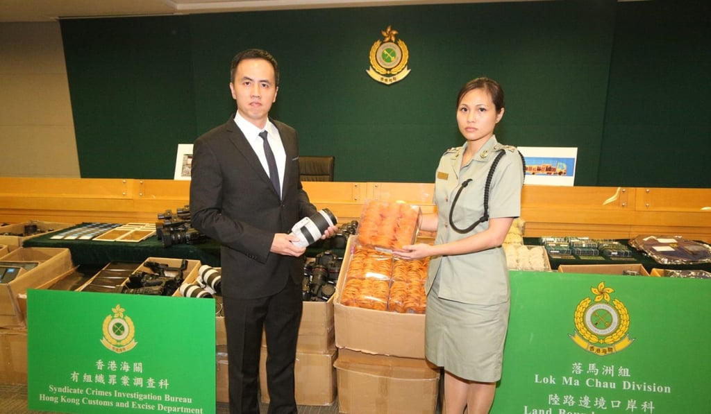 Hong Kong customs officials with the haul of luxury goods, worth HK$30 million, headed for Shenzhen, that were seized at Lok Ma Chau border crossing. Photo: Handout Hong Kong customs officials with the haul of luxury goods, worth HK$30 million, headed for Shenzhen, that were seized at Lok Ma Chau border crossing. Photo: Handout
