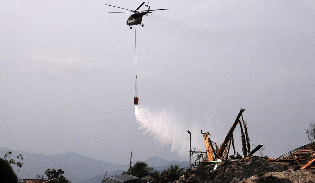 A helicopter sprays disinfectant to sterilise an area in Palu on October 18, 2018. Photo: AFP
