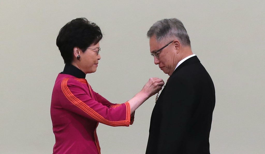 Chief Executive Carrie Lam pins the Grand Bauhinia Medal on Justice Robert Tang at Government House. Photo: Edward Wong