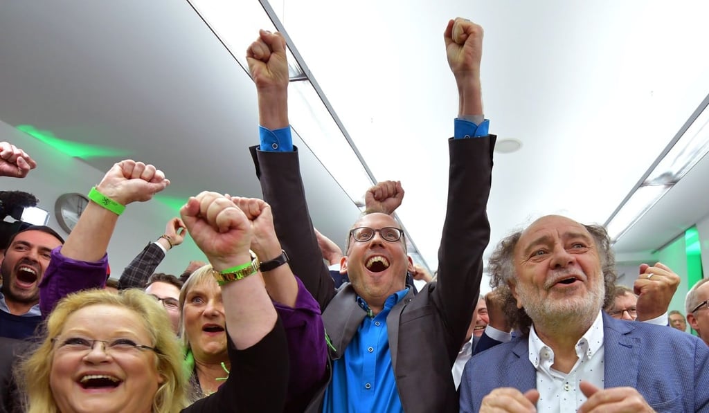 Supporters of the Green party react as first exit polls were announced on public television during the state elections in Hesse. Photo: AFP