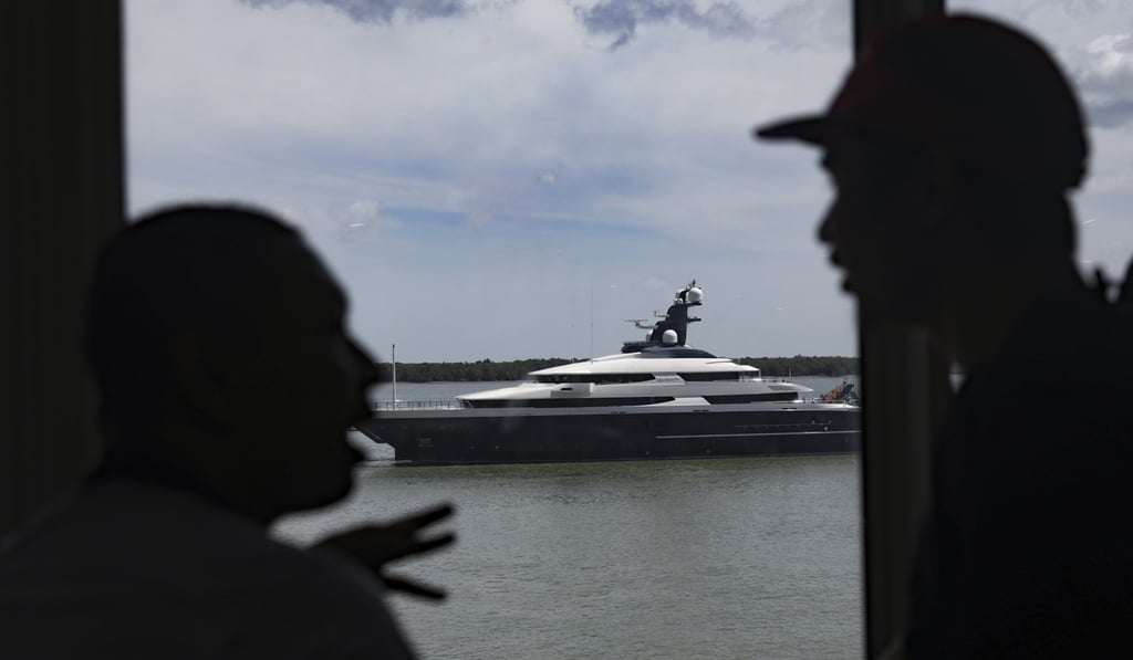 Men chat in front of the seized luxury yacht Equanimity, docked at Port Klang, Selangor, Malaysia. Photo: EPA