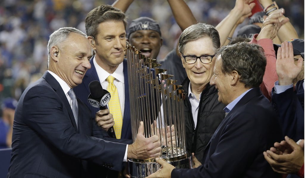 Boston Red Sox owner John Henry (second right) and chairman Tom Werner are handed the World Series trophy. Photo: EPA Boston Red Sox owner John Henry (second right) and chairman Tom Werner are handed the World Series trophy. Photo: EPA