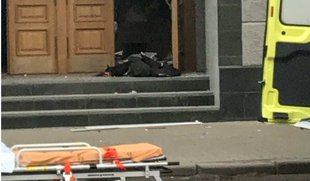 A man who set off a bomb at the FSB office lies on the ground at the entrance in Arkhangelsk, northern Russia on October 31, 2018. Photo: AP