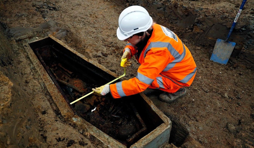 A field archaeologist measures a coffin. Photo: AFP