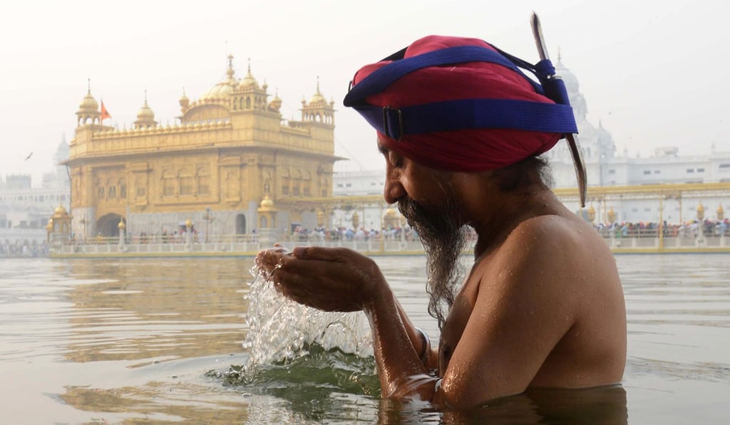 An Indian Sikh devotee bathes in front of the Golden Temple in Amritsar, India, to celebrate Diwali. Photo: AFP