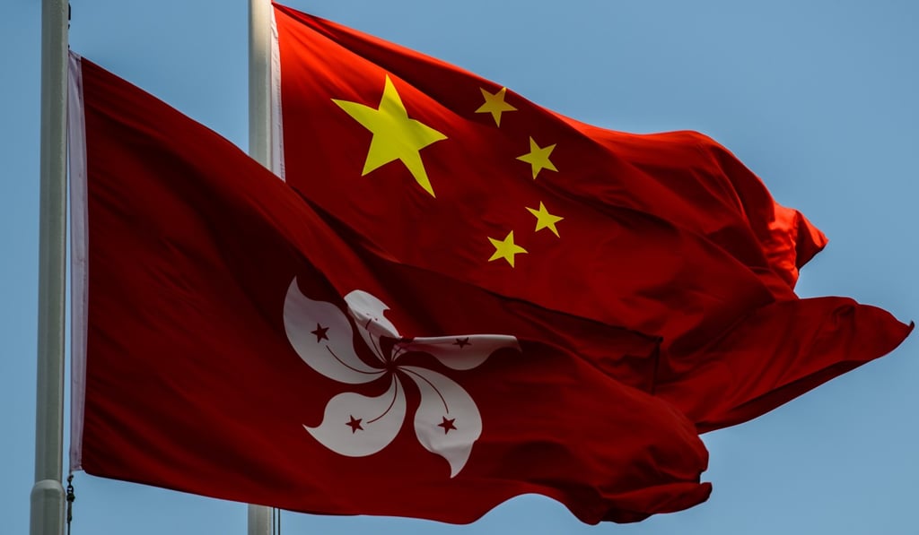 China’s flag flies over the Hong Kong emblem. Photo: AFP