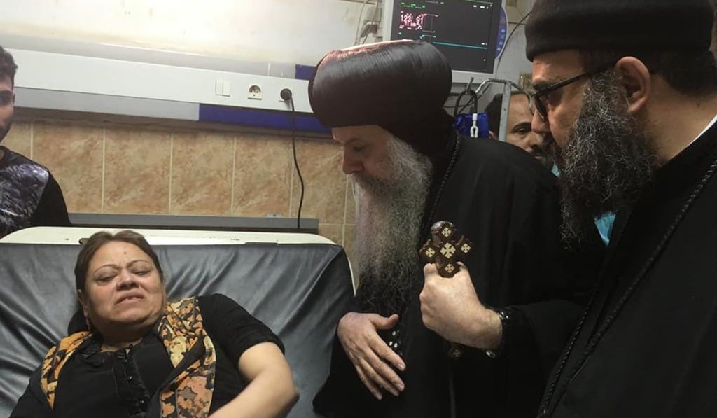 Egypt's Coptic priest Agathon (centre) speaks to a woman who was wounded after gunmen attacked a bus carrying Coptic Christians at the Sheikh Fadel hospital in Beni Mazar on Friday. Photo: Agence France-Presse