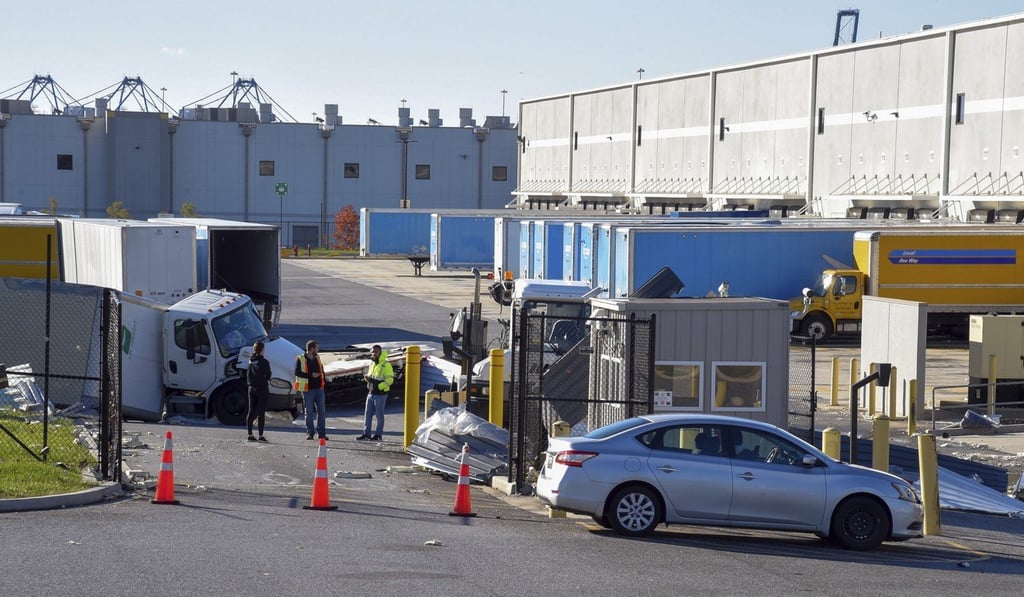 People look over a damaged truck after a weather-related building collapse at an Amazon distribution warehouse on Baltimore's southeast side Friday night. Photo: The Baltimore Sun via AP