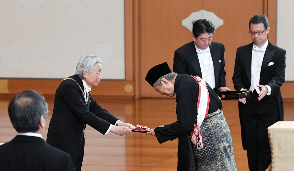 Malaysia’s Prime Minister Mahathir Mohamad bows as he receives the Grand Cordon of the Order of the Paulownia Flowers from Japan’s Emperor Akihito. Photo: EPA