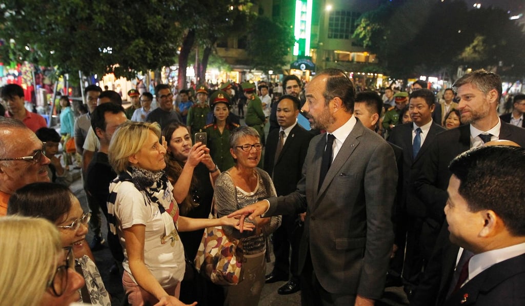 Philippe talking to a tourist as he walks around the Hoan Kiem lake area of Hanoi, Vietnam on Saturday. Photo: EPA