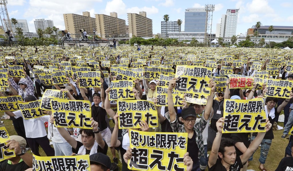 Anti-base protesters in Okinawa hold placards that read: “Our anger has reached its limit”. Photo: Kyodo