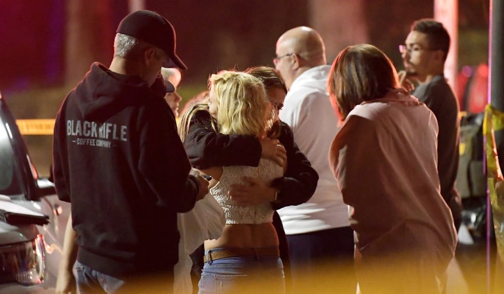 People comfort each other in Thousand Oaks, California, where a gunman opened fire Wednesday inside a country dance bar crowded with hundreds of people. Photo: AP