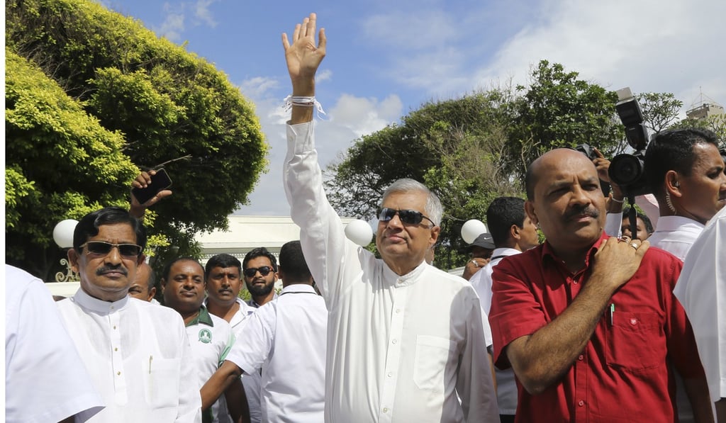 Sri Lanka’s ousted prime minister Ranil Wickremesinghe (centre) waves as members of his United National Party (UNP) take part in a parade demanding that Parliament be convened in Colombo on Thursday. Photo: AP