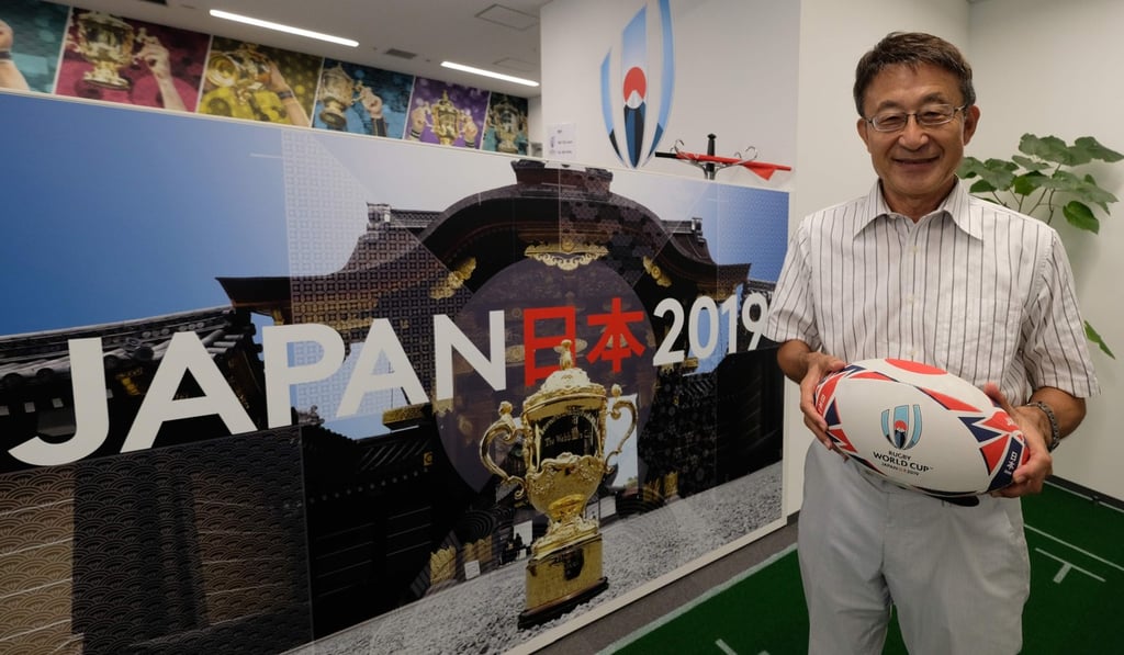 Koji Tokumasu, senior director of the World Cup organising committee and former Asia Rugby boss, posing with a campaign poster of the 2019 Rugby World Cup, in Tokyo. Photo: AFP