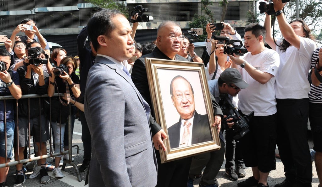 Andrew Cha holds a portrait of his father Louis Cha as he leaves Hong Kong Funeral Home in Quarry Bay on Tuesday morning. Photo: Felix Wong Andrew Cha holds a portrait of his father Louis Cha as he leaves Hong Kong Funeral Home in Quarry Bay on Tuesday morning. Photo: Felix Wong