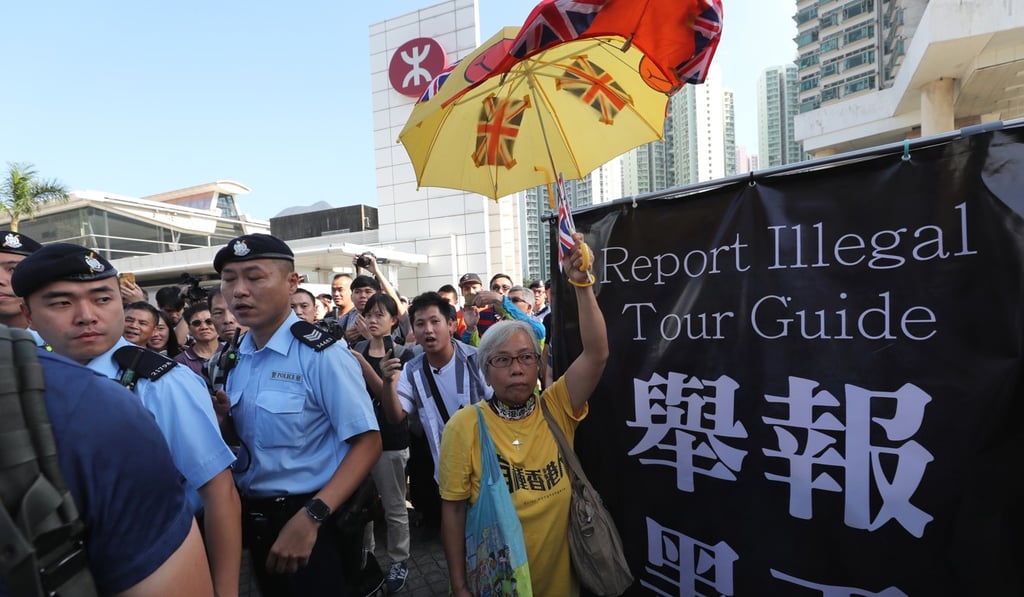 A woman holds an umbrella decorated with the union flag while protesting against illegal tour guides in Tung Chung. Photo: Sam Tsang