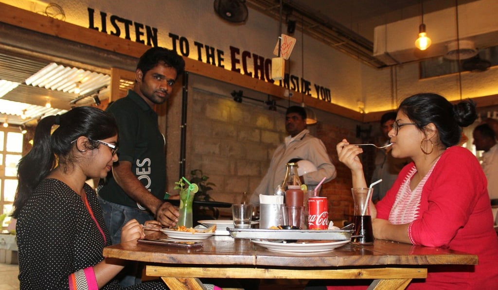 Hearing-impaired waiter Dadaper serves customers at Echoes Koramangala restaurant.