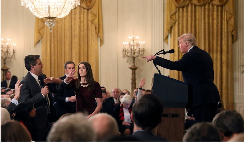 A White House communications intern reaches for the microphone held by CNN’s Jim Acosta as he asks US President Donald Trump a question on November 7. Photo: Reuters