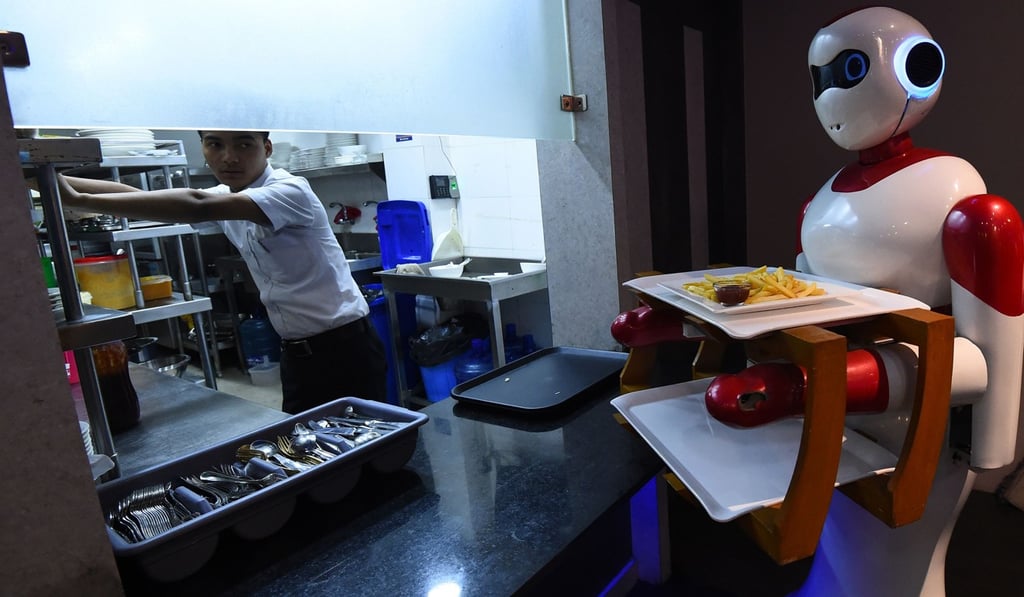 A robot waiter picks up food from the kitchen to bring to customers at Naulo restaurant in Kathmandu. Photo: AFP