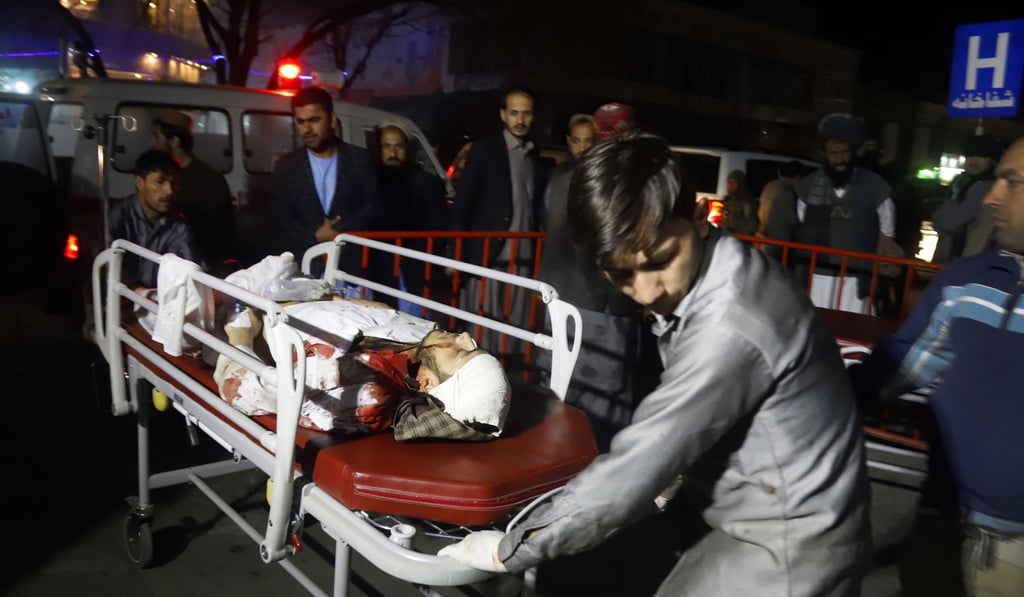 Afghan health workers carry an injured person to an ambulance after a suicide attack targeted a wedding hall in Kabul, Afghanistan on November 20, 2018. Photo: EPA