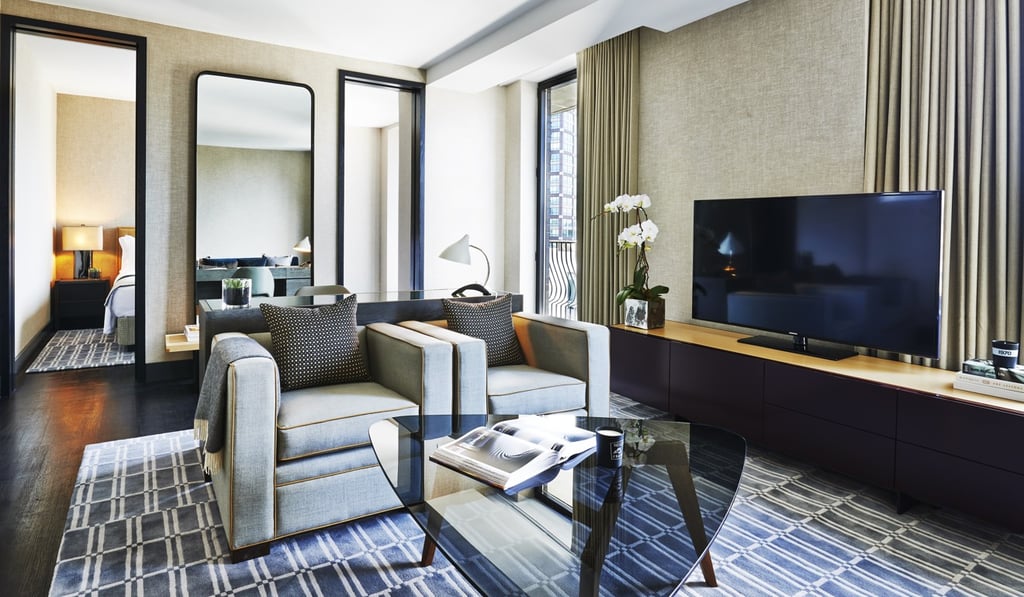 A large upright, wall-mounted mirror reflects light from windows and adds depth to a room at the boutique hotel SIXTY SoHo Hotel in New York.