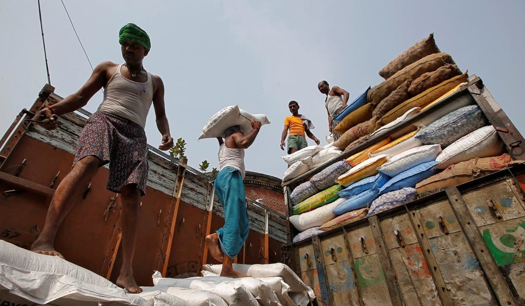 Labourers load a supply truck with sacks of sugar in Kolkata. Photo: Reuters