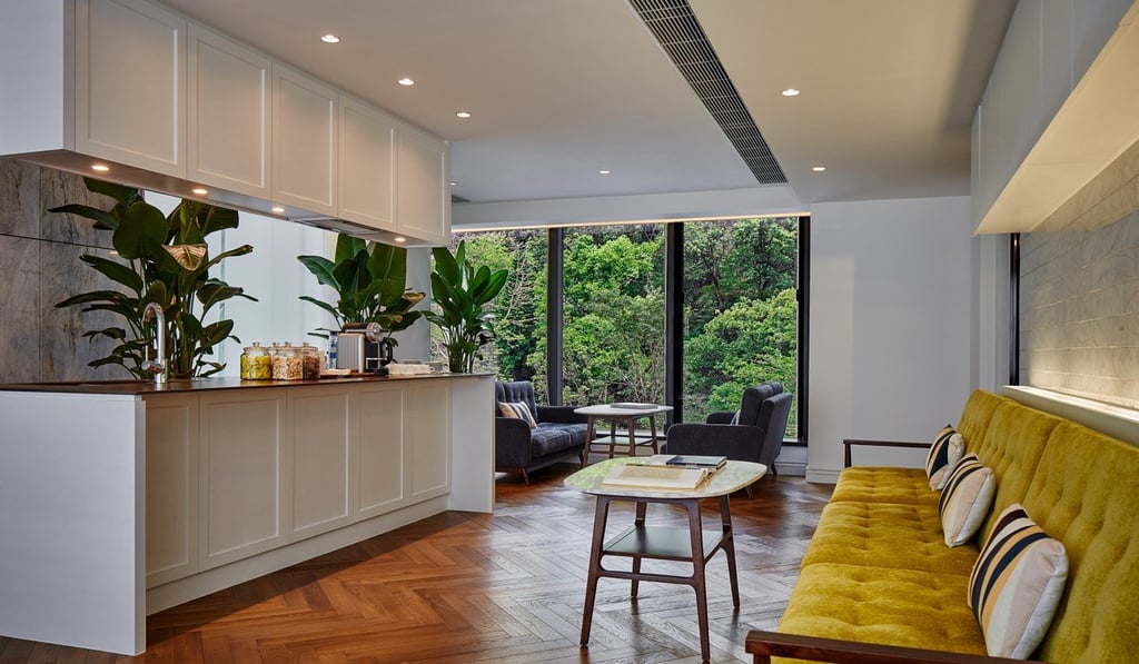 A large, bright-coloured sofa adds a warm, welcoming touch to the interior of Little Tai Hang boutique hotel in Hong Kong.