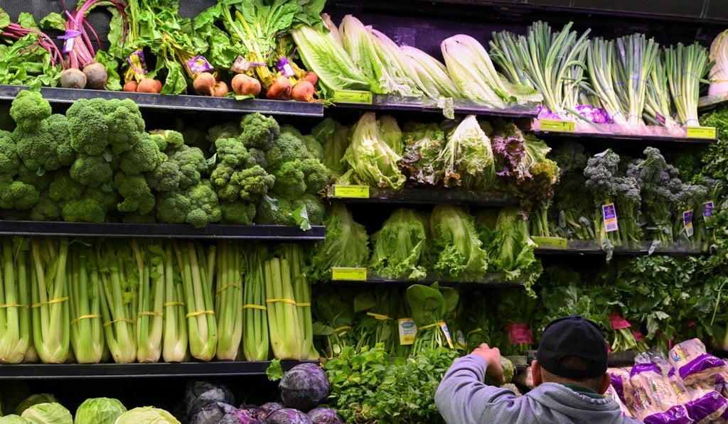 A produce worker stocks shelves near romaine lettuce (top shelf centre) at a Whole Foods supermarket in Washington on Tuesday. Photo: AP