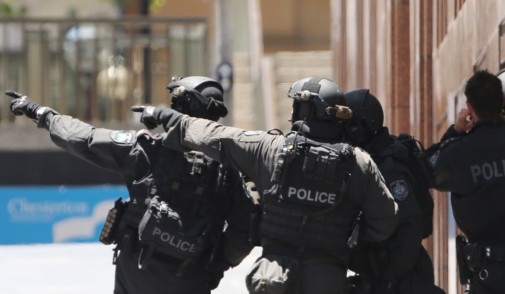 Armed police officers at a cafe under siege at Martin Place in Sydney. Photo: AP
