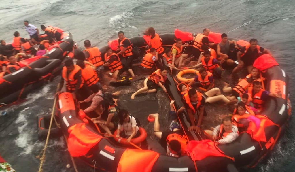 Rescued tourists are brought aboard a fishing boat after the ferry disaster. Photo: EPA