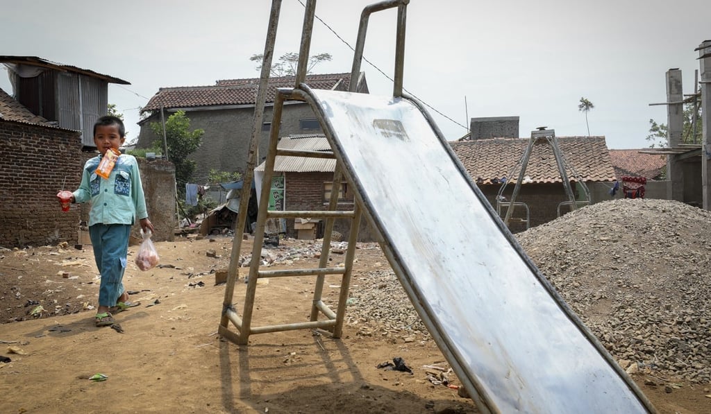 A child passes next to a slide in a slum in Bandung, Indonesia. Photo: James Wendlinger