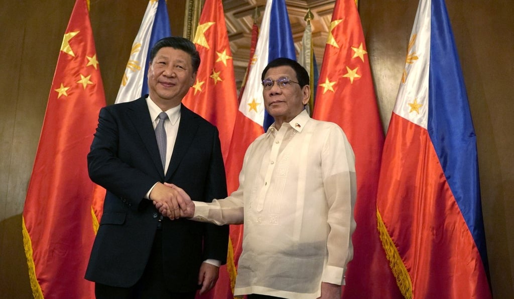 Xi and Duterte shake hands in front of their countries’ flags. Photo: EPA