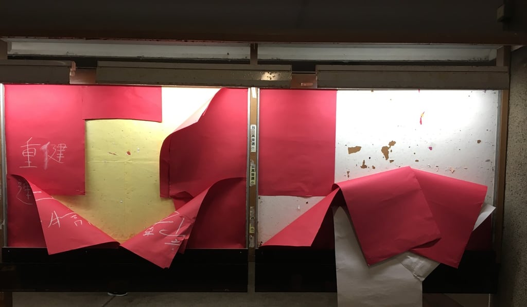 Torn red sheets of paper hang off a bulletin board at Polytechnic University. Photo: Alvin Lum