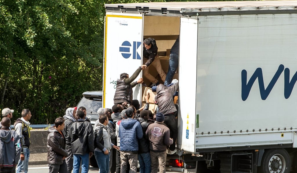 File phot of migrants climbing into the back of a lorry in France that is heading for Britain. Photo: AFP