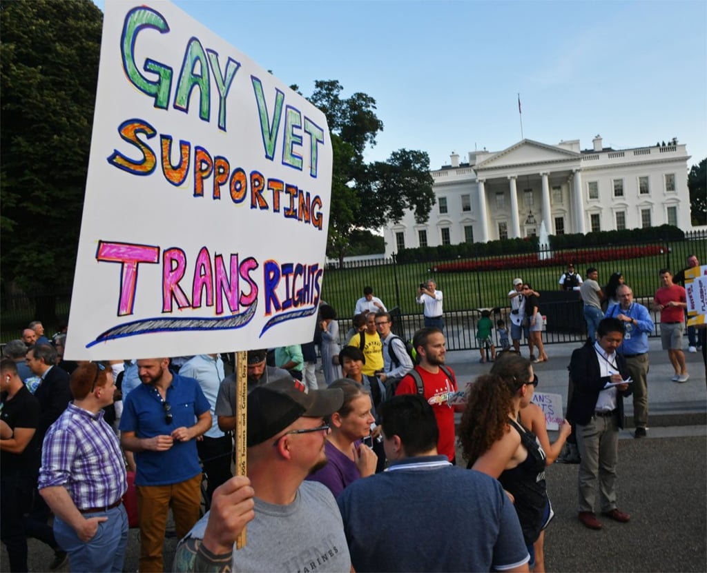People, including a supporter of transgender military personnel, stand in front of the White House in August, 2017.