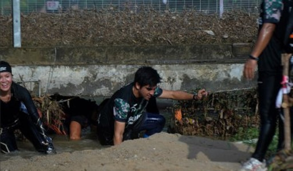 Syed Saddiq crawls under a wall during the Warriors Challenge.