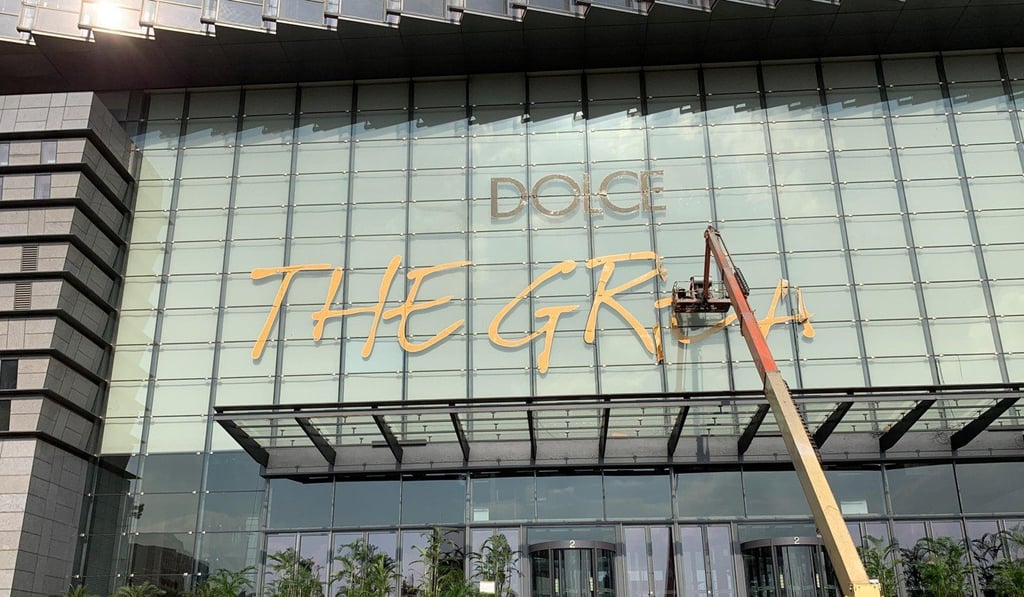 Workers remove signs “Dolce & Gabbana The Great Show” sign from outside the Shanghai Expo Center. Photo: Reuters