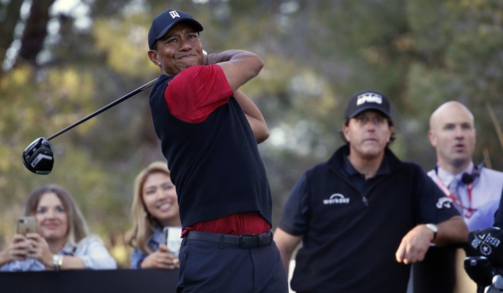 Tiger Woods hits off the 16th tee as Phil Mickelson watches. Photo: AP Tiger Woods hits off the 16th tee as Phil Mickelson watches. Photo: AP