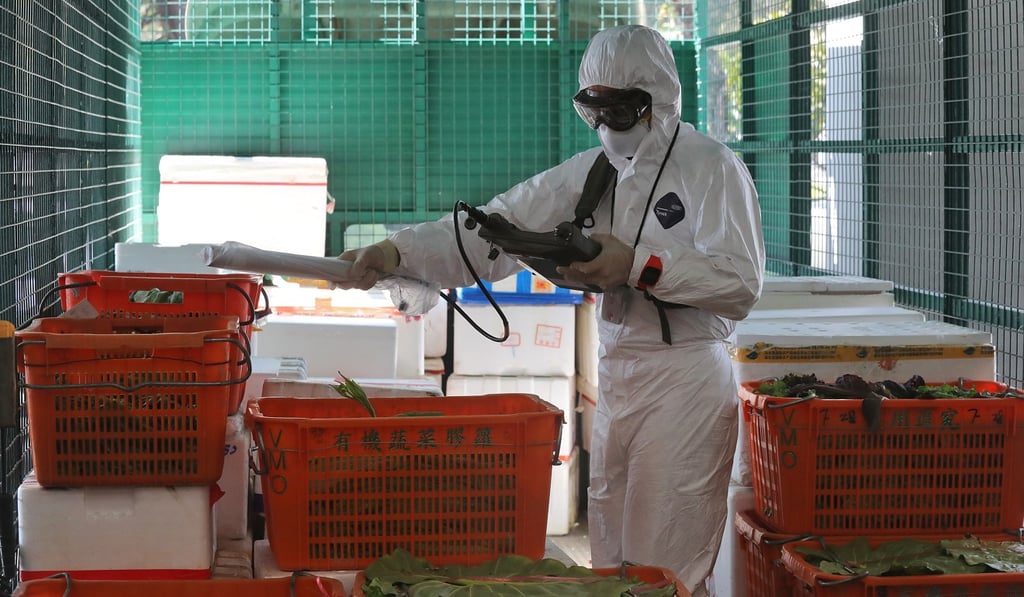 A worker at the Man Kam To checkpoint inspects food as part of an exercise. Photo: K.Y. Cheng
