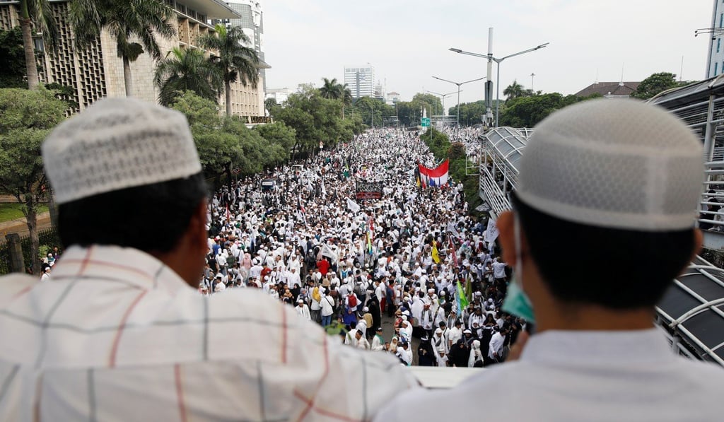 Men watch the rally in Jakarta. Photo: Reuters