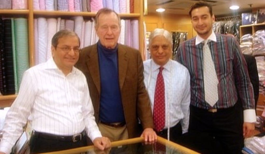 Bush with Manu Melwani (second from right) and his son Roshan (right). Photo: Handout Bush with Manu Melwani (second from right) and his son Roshan (right). Photo: Handout