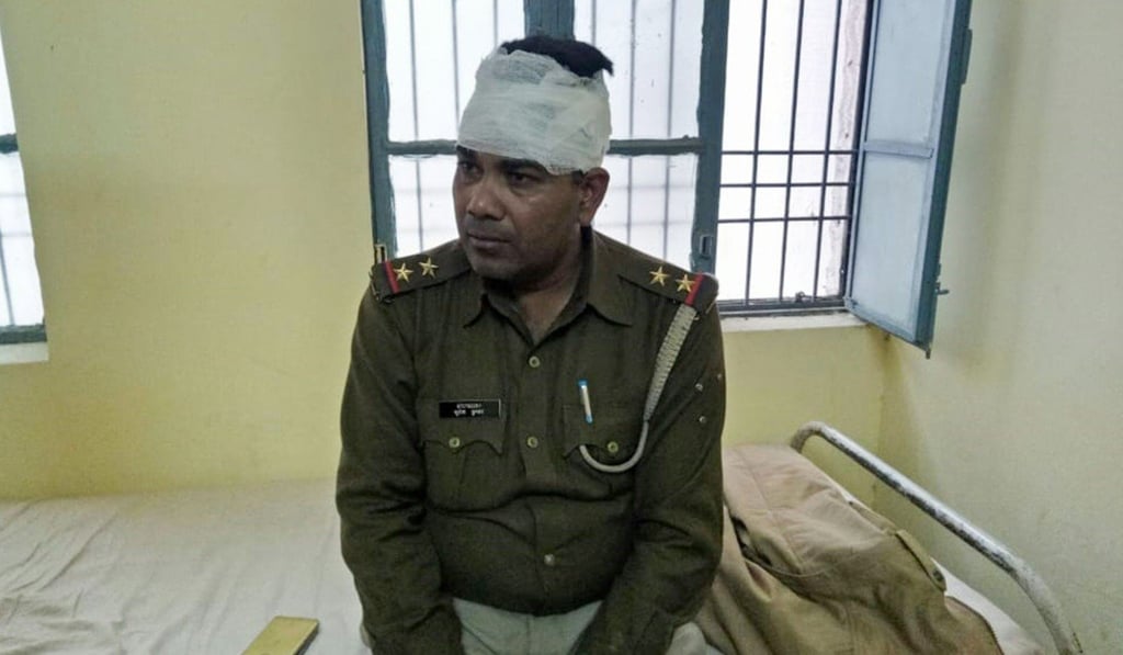 An Indian policeman looks on after receiving treatment for a head injury following mob violence at Chingravati village. Photo: AFP