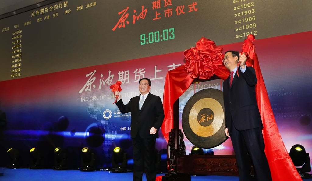 Li Qiang (left), the top Communist Party official in Shanghai, and Liu Shiyu, chairman of the China Securities Regulatory Commission, hit the gong together to signal the start of trading of China's yuan-dominated crude oil futures contract at the Shanghai International Energy Exchange on March 26. Photo: Xinhua