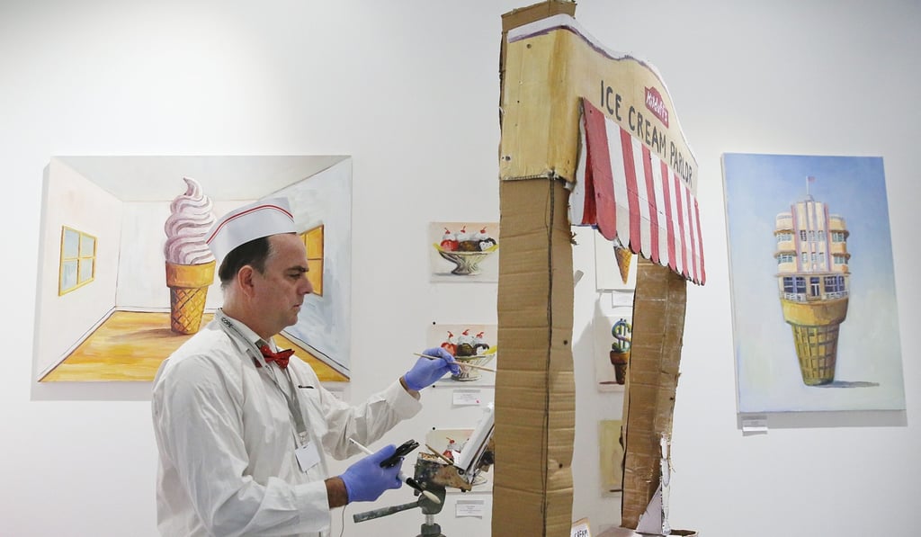 Artist John Kilduff paints ice-cream portraits in front of his ice cream parlour paintings during Art Basel. Photo: AP Photo Artist John Kilduff paints ice-cream portraits in front of his ice cream parlour paintings during Art Basel. Photo: AP Photo